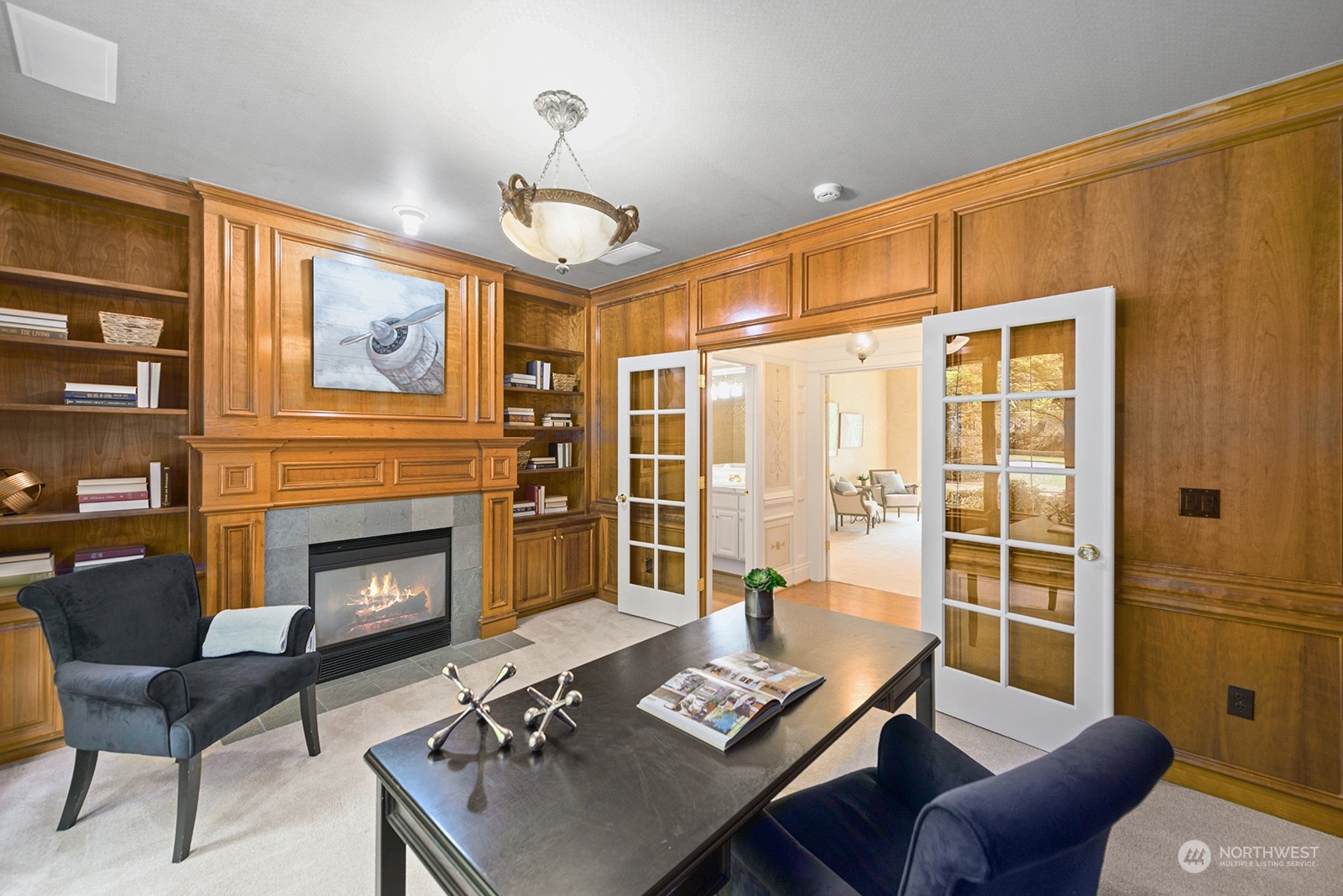 Private office with beautiful wood finishes, complete with built-in shelving, cabinets and fireplace.