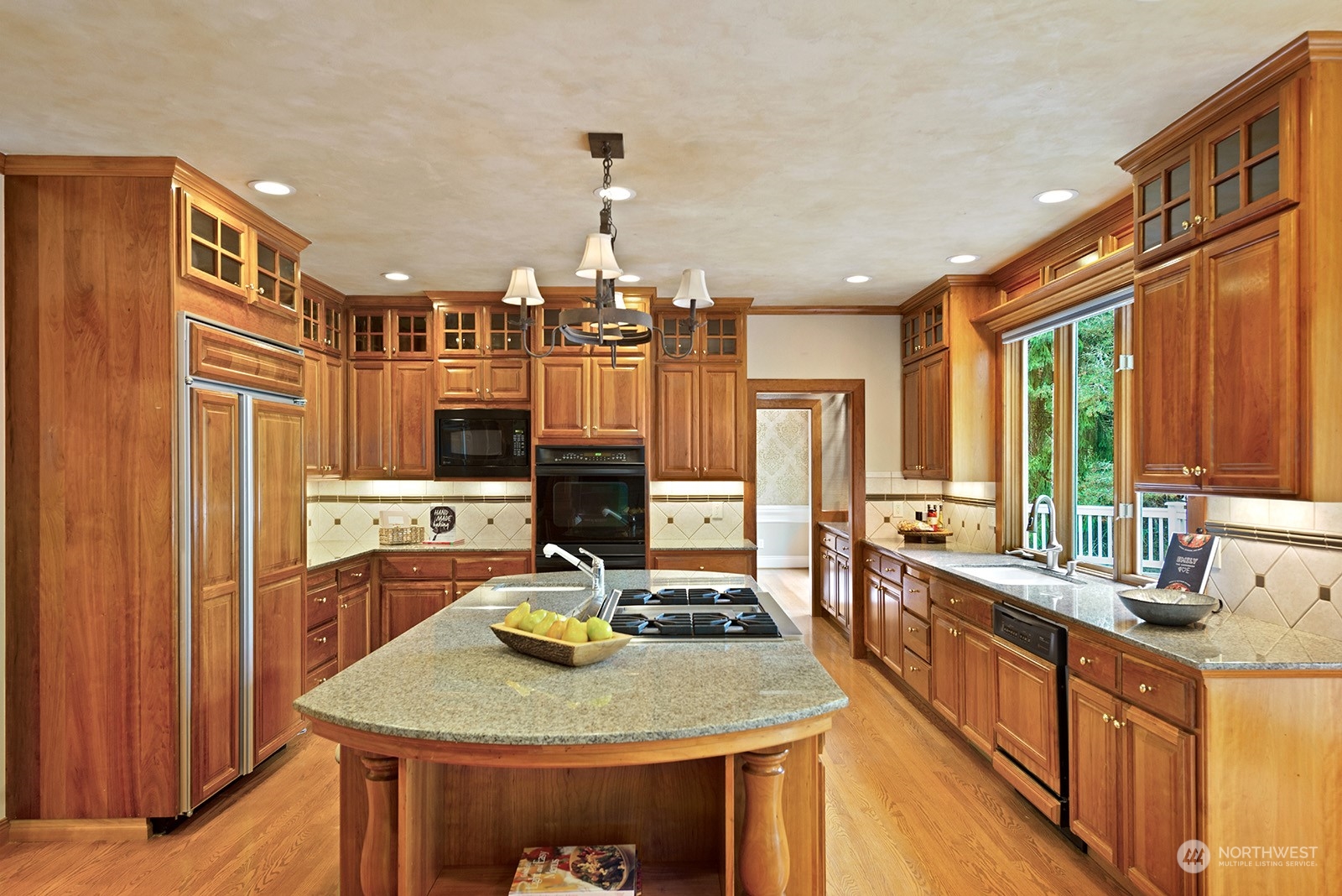 Gourmet kitchen with granite slab countertops, custom tile backsplash, under cabinet lighting and distinguished cherry cabinets.