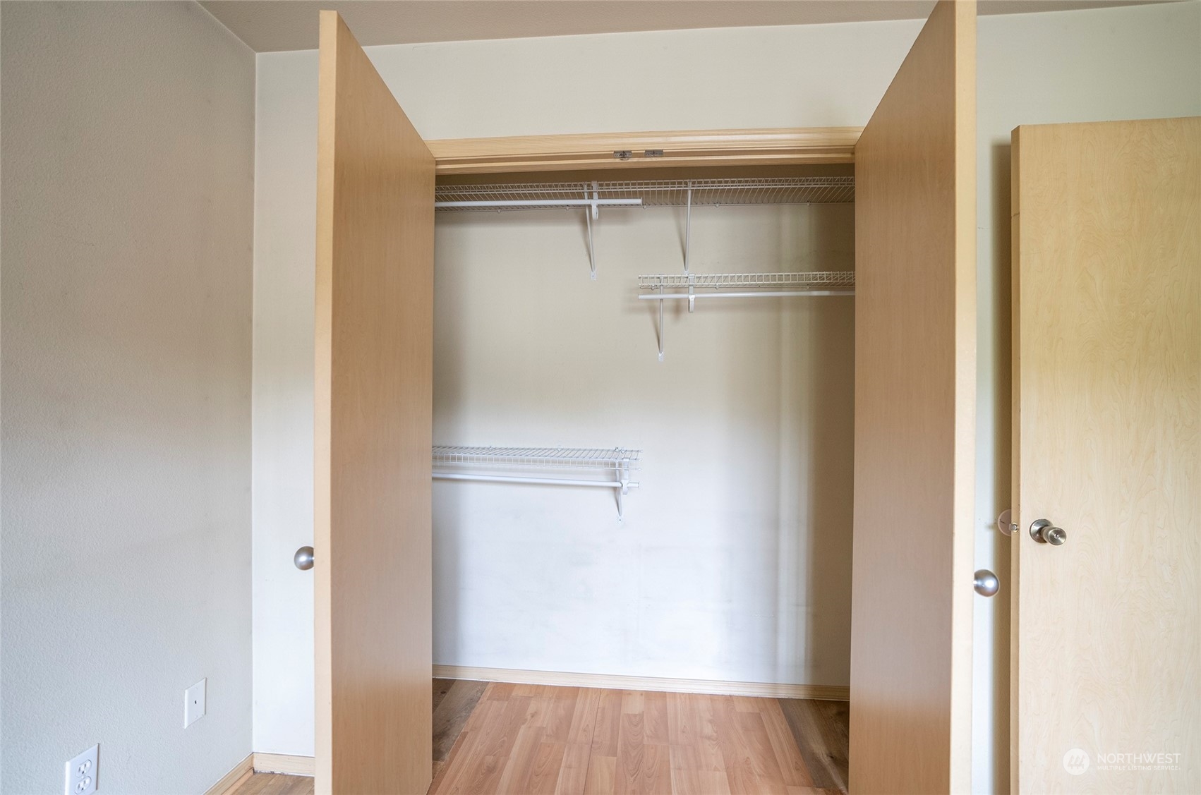 The primary suite closet is equipped with shelving and ample space for hanging clothes.