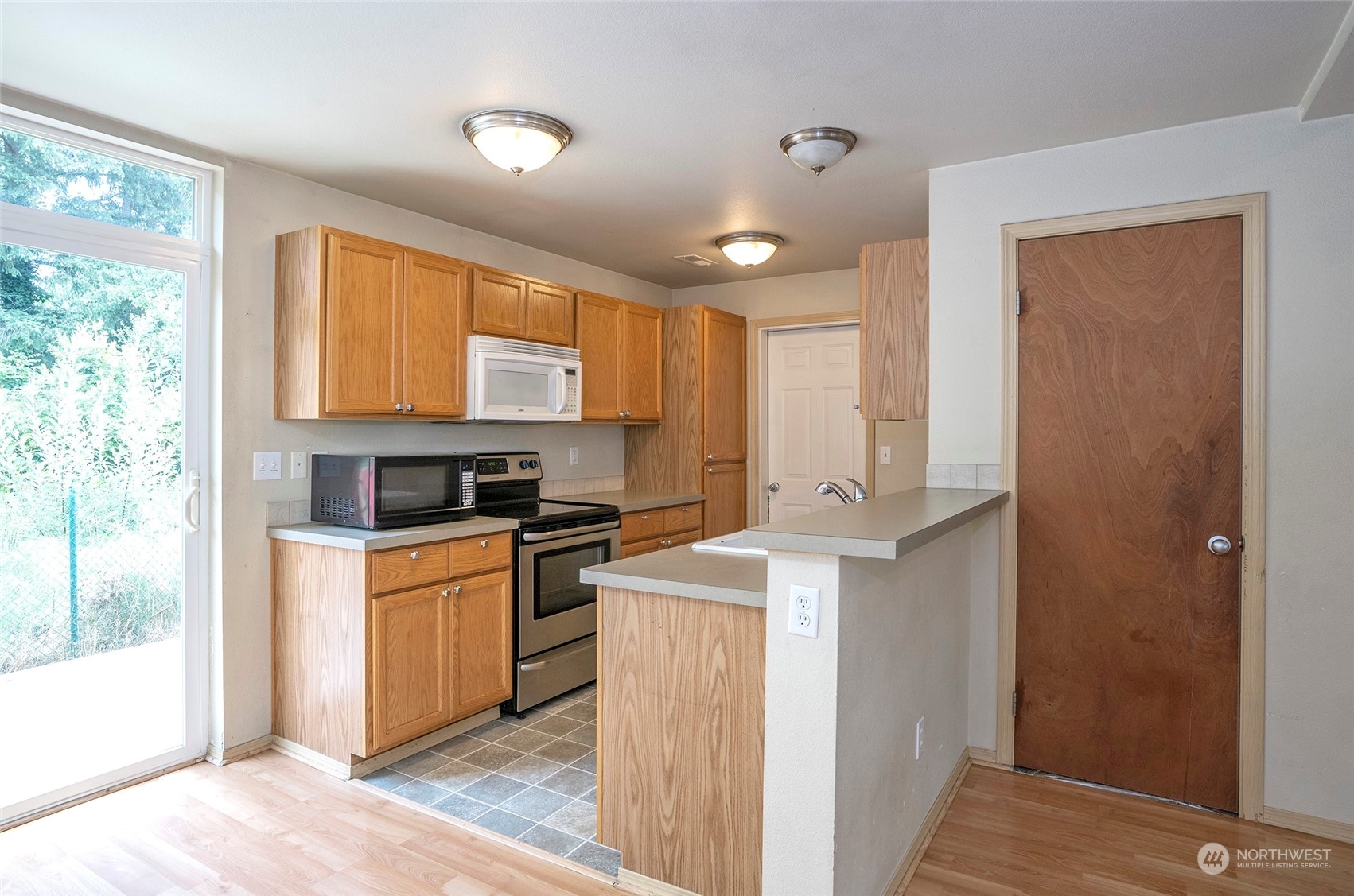 Oak-framed kitchen cabinets complemented by a stylish tile backsplash. Adding bar stools to the eating bar would make it the perfect spot for casual dining.