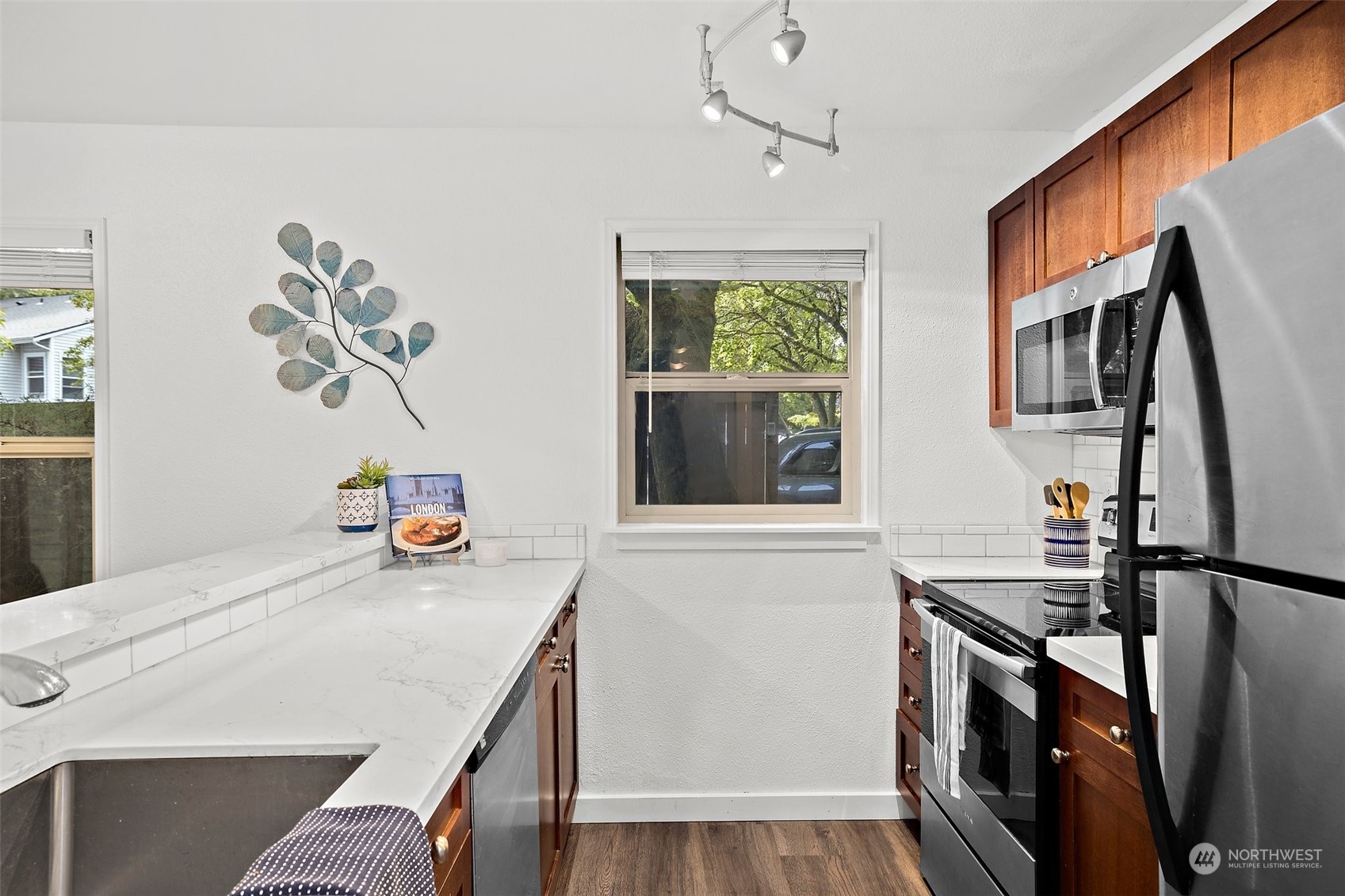 Light filled kitchen with newer stainless steel appliances.