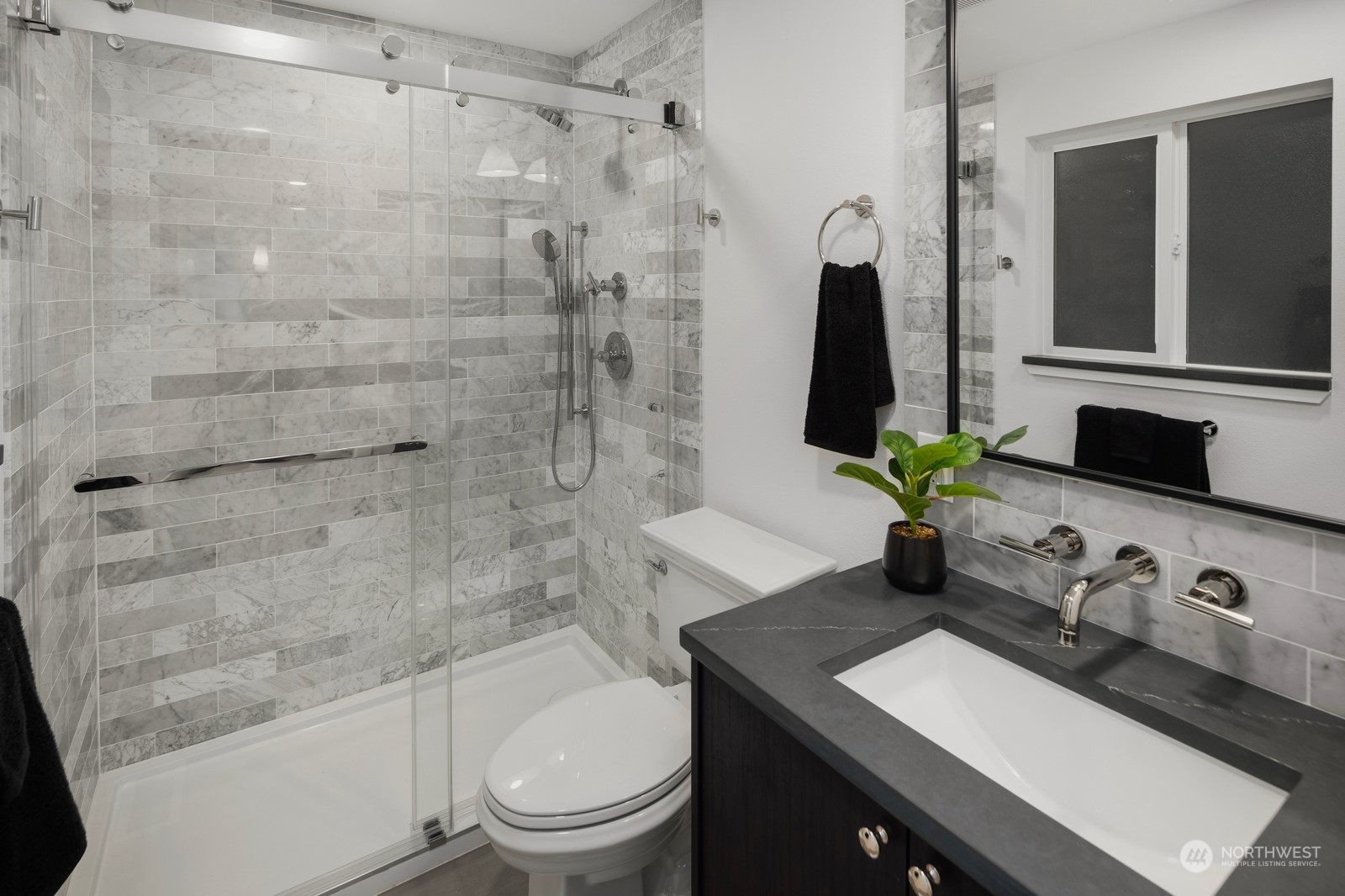 Praimary bathroom with full height stone backsplash at sink, heated floors, and lavish shower.