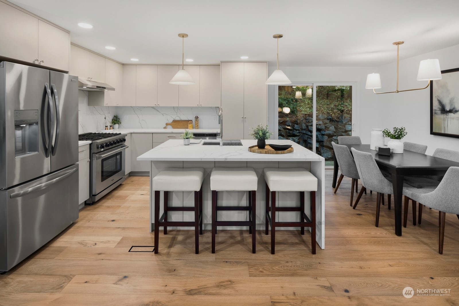 Cabinets all custom designed and hand crafted. Under island additional cabinet space, gas range and full height solid slab quartz backsplash.