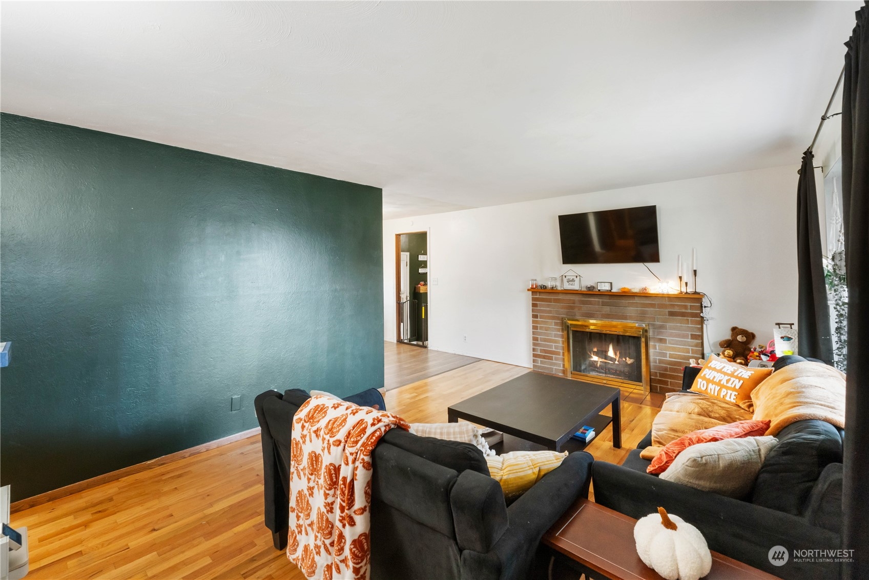 At entry, notice the large accent wall, hardwood floors and the bright light that fills this space.