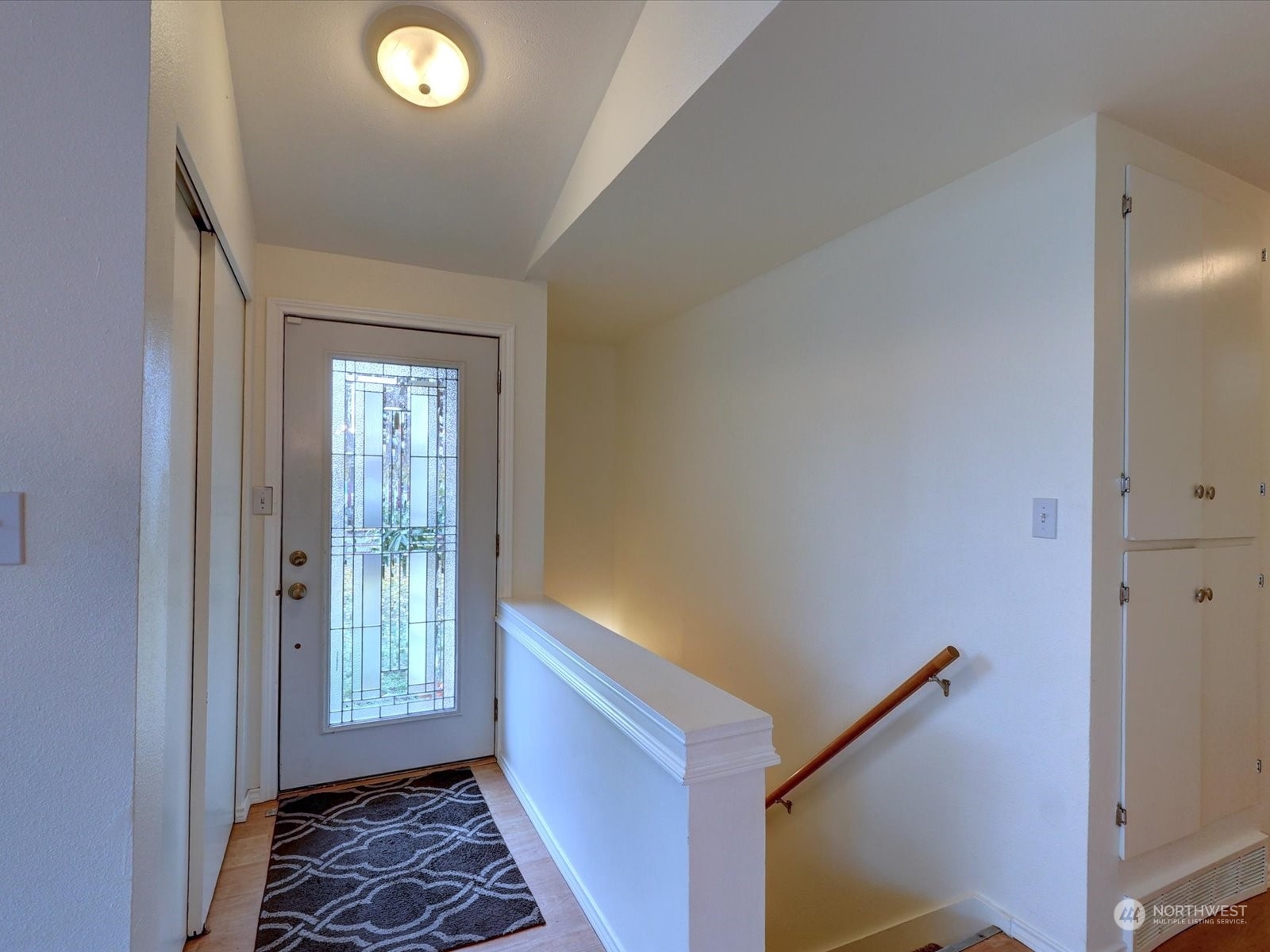 Front door and stairway to lower level. Hallway to two bedrooms and full bath on the right.