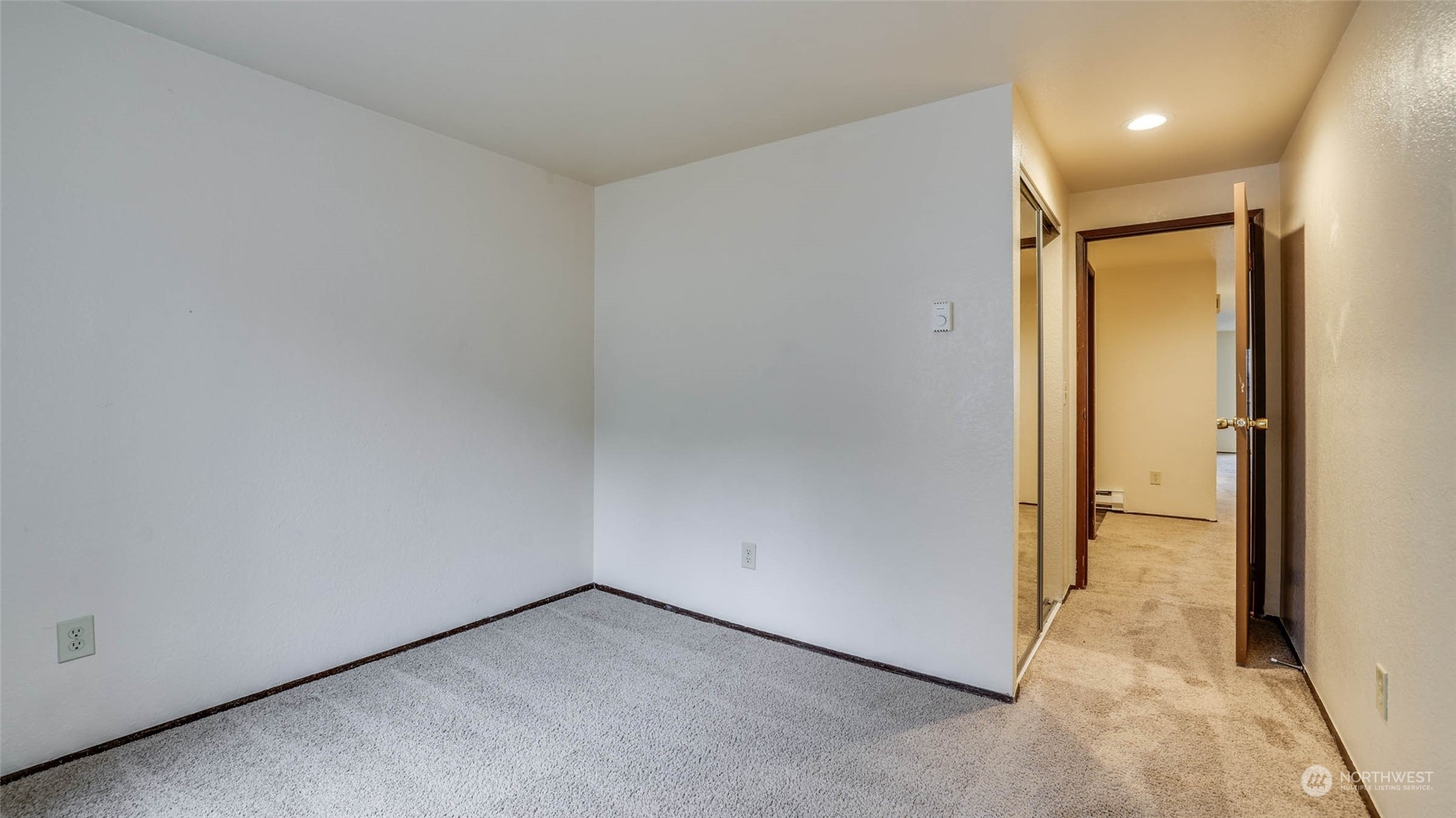 Another angle of the guest bedroom; more of the natural light along with mirrored closet doors maximize the space.