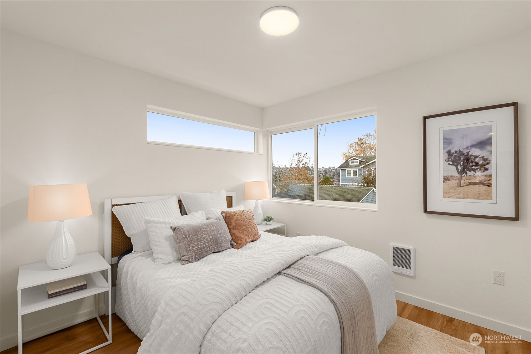 A peaceful bedroom with views of the surrounding neighborhood offers a cozy ambiance and modern design. Perfect for creating your haven.