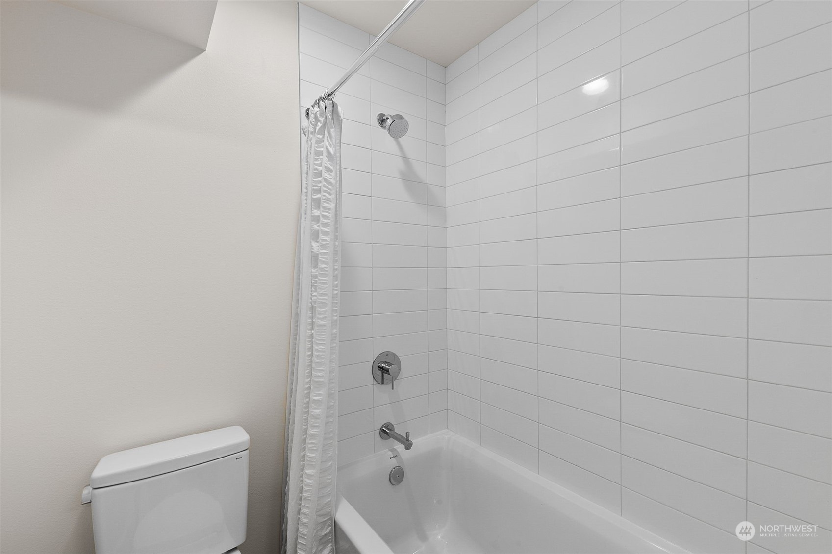 A fresh and inviting shower area featuring crisp white tiles. Simple, clean, and perfect for a relaxing rinse.