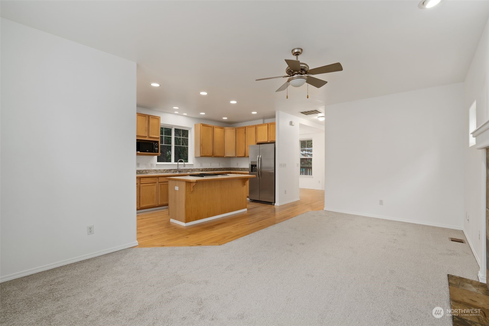 Living Area: Open floor plan with fireplace and hardwood floors.