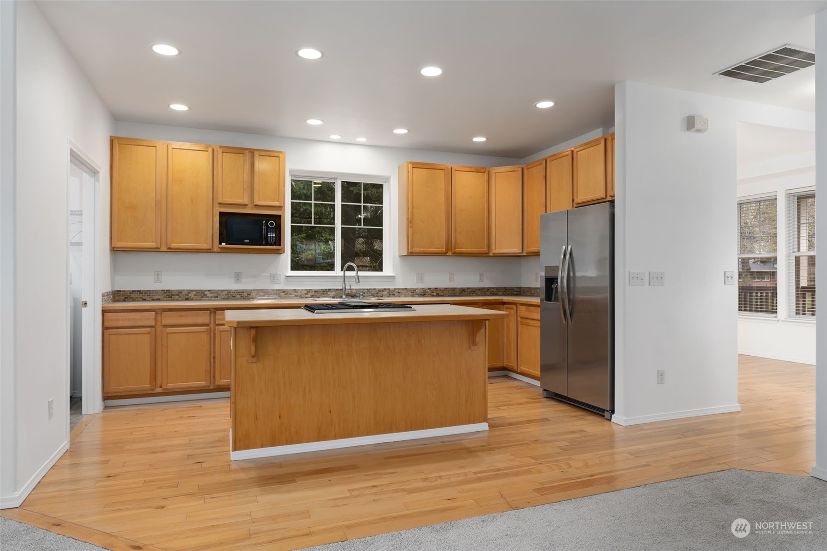 Living Area: Open floor plan with fireplace and hardwood floors.