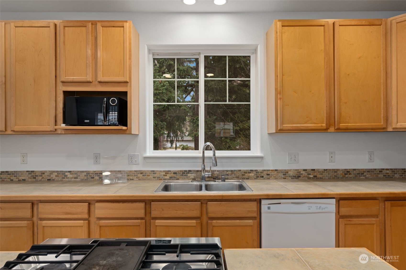 Kitchen: Spacious with wood cabinets and tile backsplash.