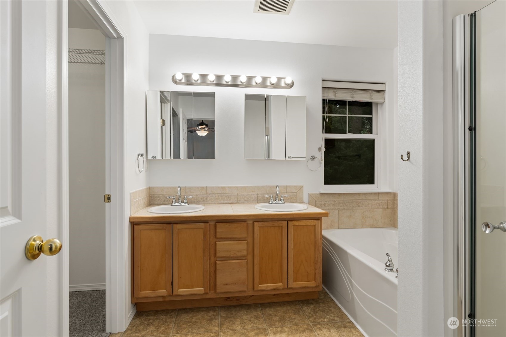 Primary Bathroom: Spacious bathroom with dual sinks, soaking tub, and a separate shower.