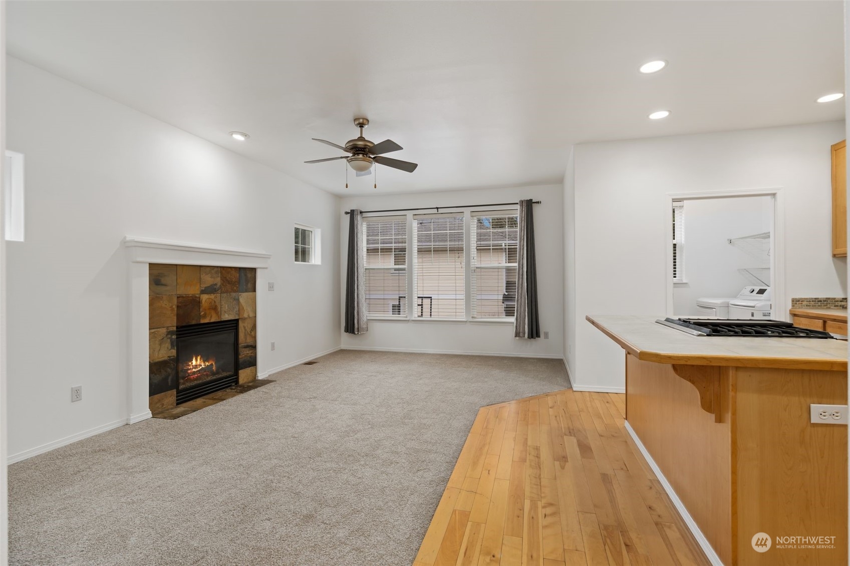 Living Room: Open floor plan with large windows and hardwood floors leading to the kitchen.