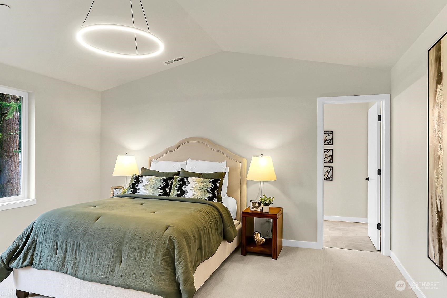 The vaulted primary bedroom is spacious and overlooks the backyard.