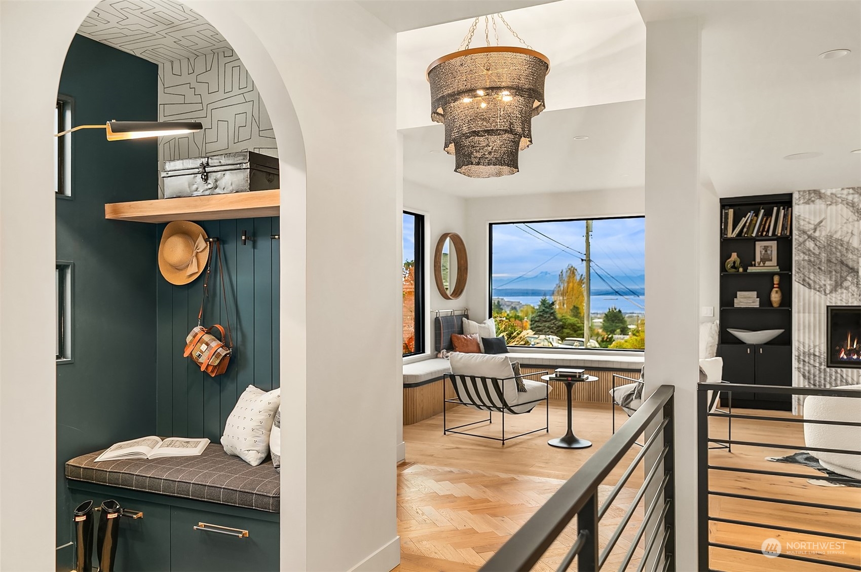 Chandelier at entrance, arch entry into darling mudroom with bench seating, storage and Elkay water bottle filling station.