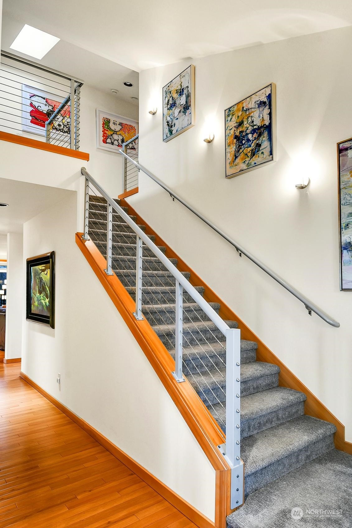 Wide, modern stairs lead to the upper level, featuring sleek cable railing and an open, airy design that perfectly complements the home’s contemporary style.