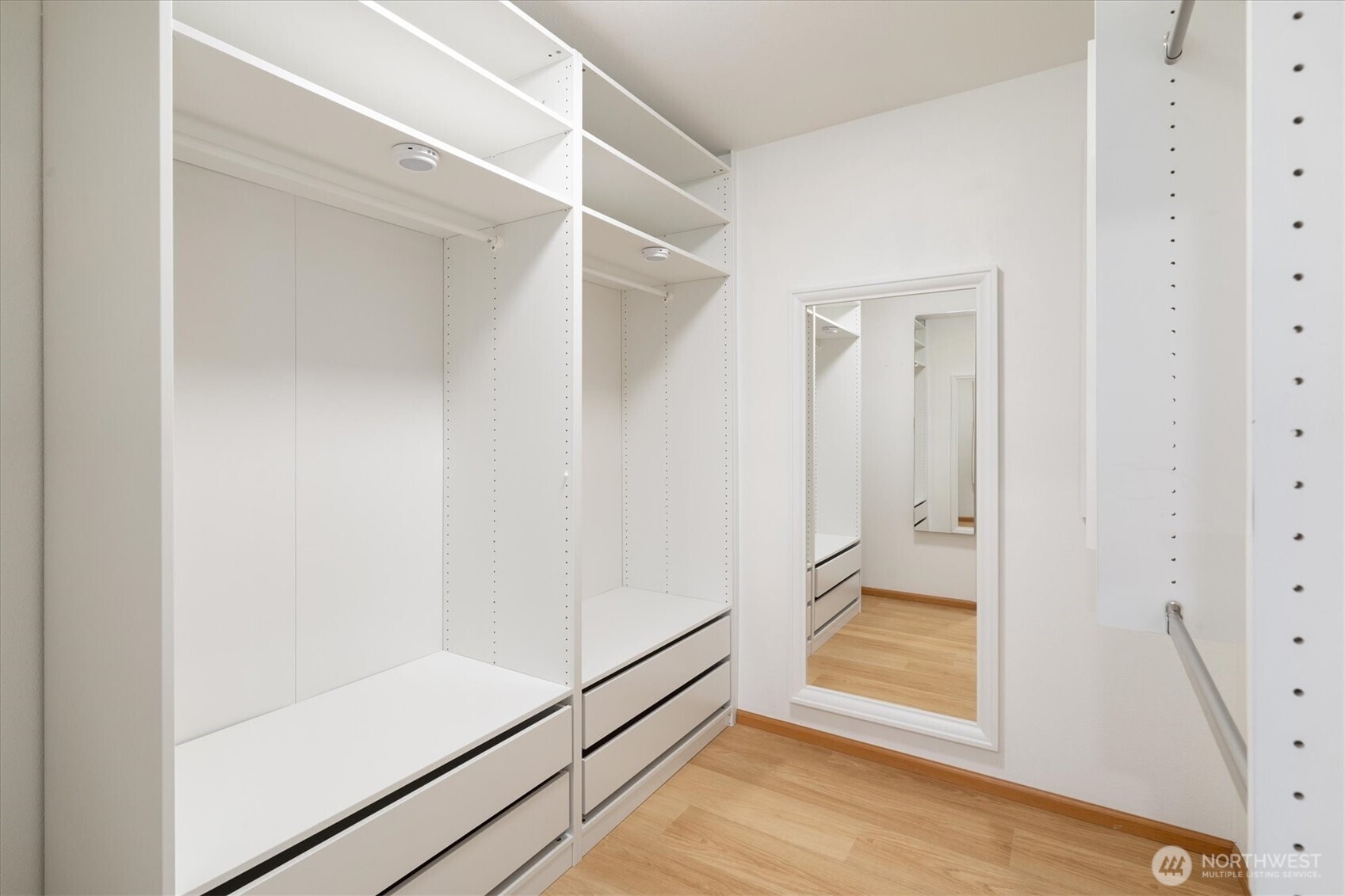 The spacious walk-in closet is equipped with built-in shelves and drawers for organized storage.