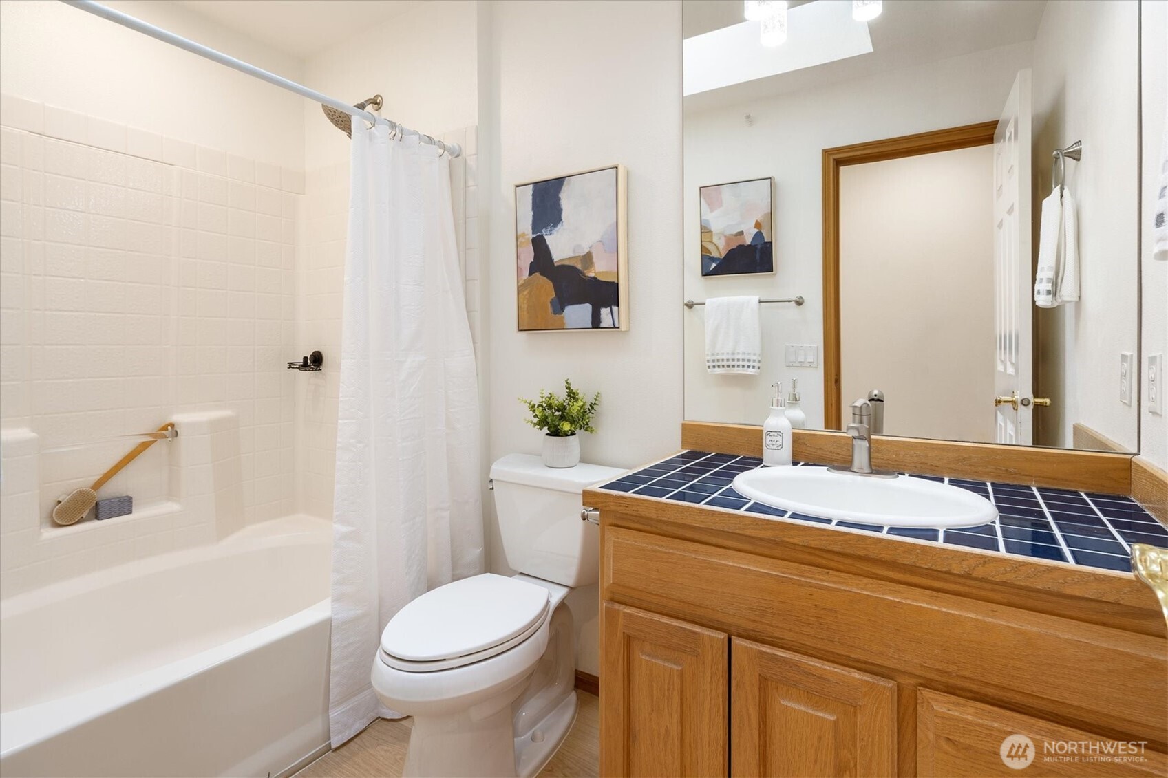 The second bathroom features an oversized bathtub, updated fixtures, and a large skylight.