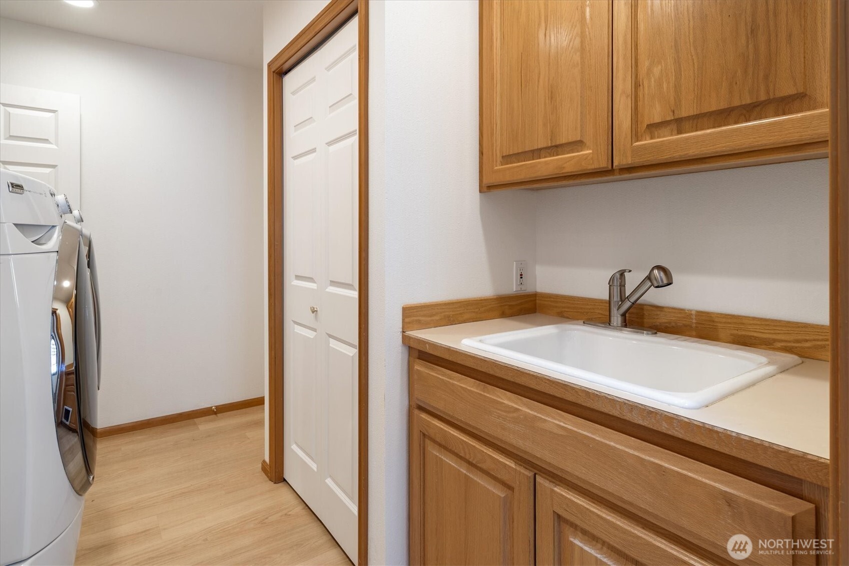 The laundry area, complete with a utility sink and generous storage, makes daily chores a breeze, with a full-size washer and dryer at your service.