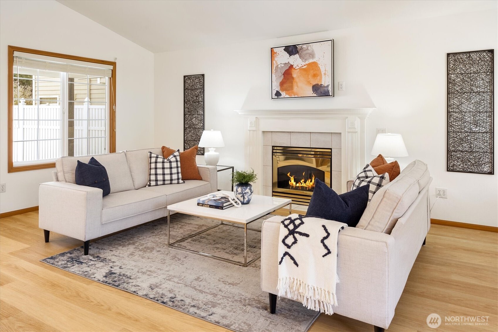 Experience the warmth and charm of the living room, relaxing by the gas fireplace, elegantly framed by a wood mantle and millwork, with large windows on either side.