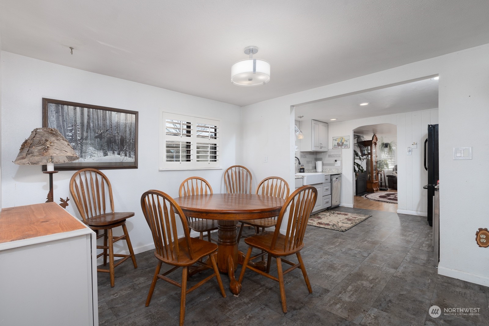 Nice dining room area with updated light fixture and featuring plantation shutters.