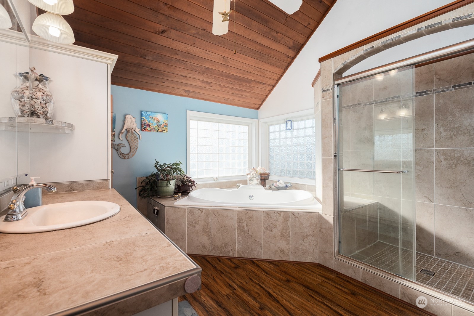 What a surprise to find this super cool bathroom here!  Cedar planked ceiling over a heated jacuzzi style soaking tub. The glass block windows let in light and keep it private! The unique walk in shower is oversized and totally tiled!  The flooring has been updated as well as the lighting too.