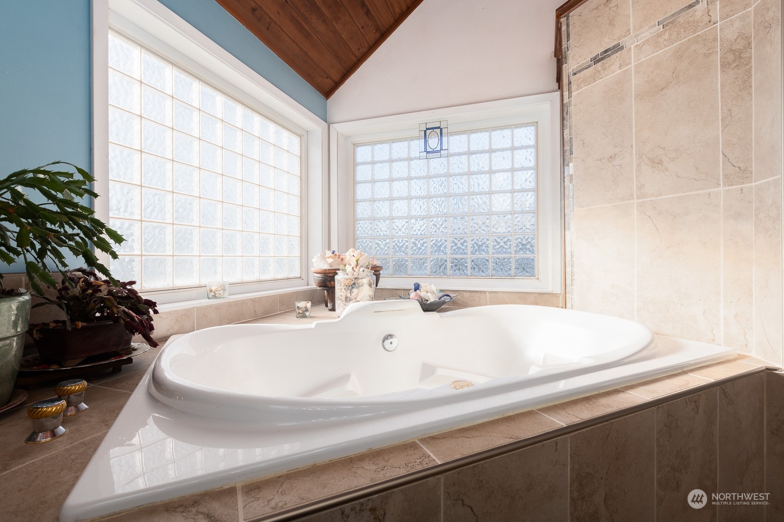 You can spend many hours soaking in warm water! The faucet is a waterfall style and is quite soothing. Tile all around and glass block windows provide light as well as privacy.