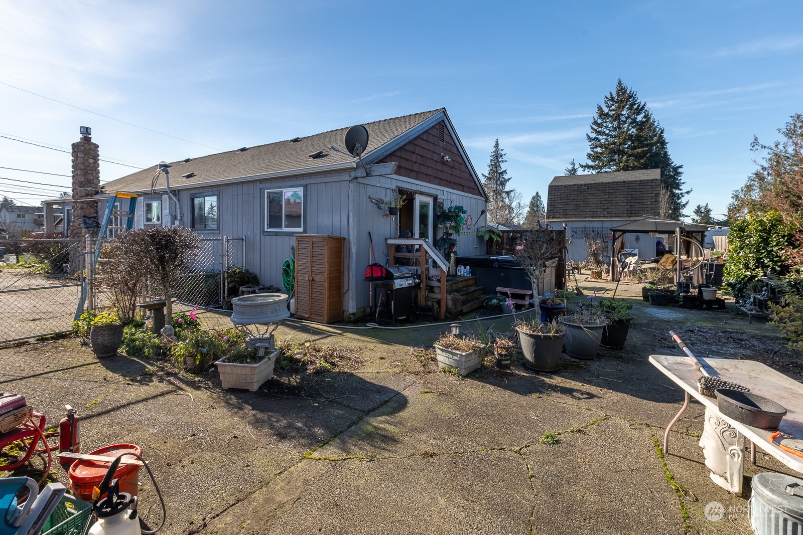 Back side of house.  220 amp service is located here. The hot tub was sold and is going to be gone.