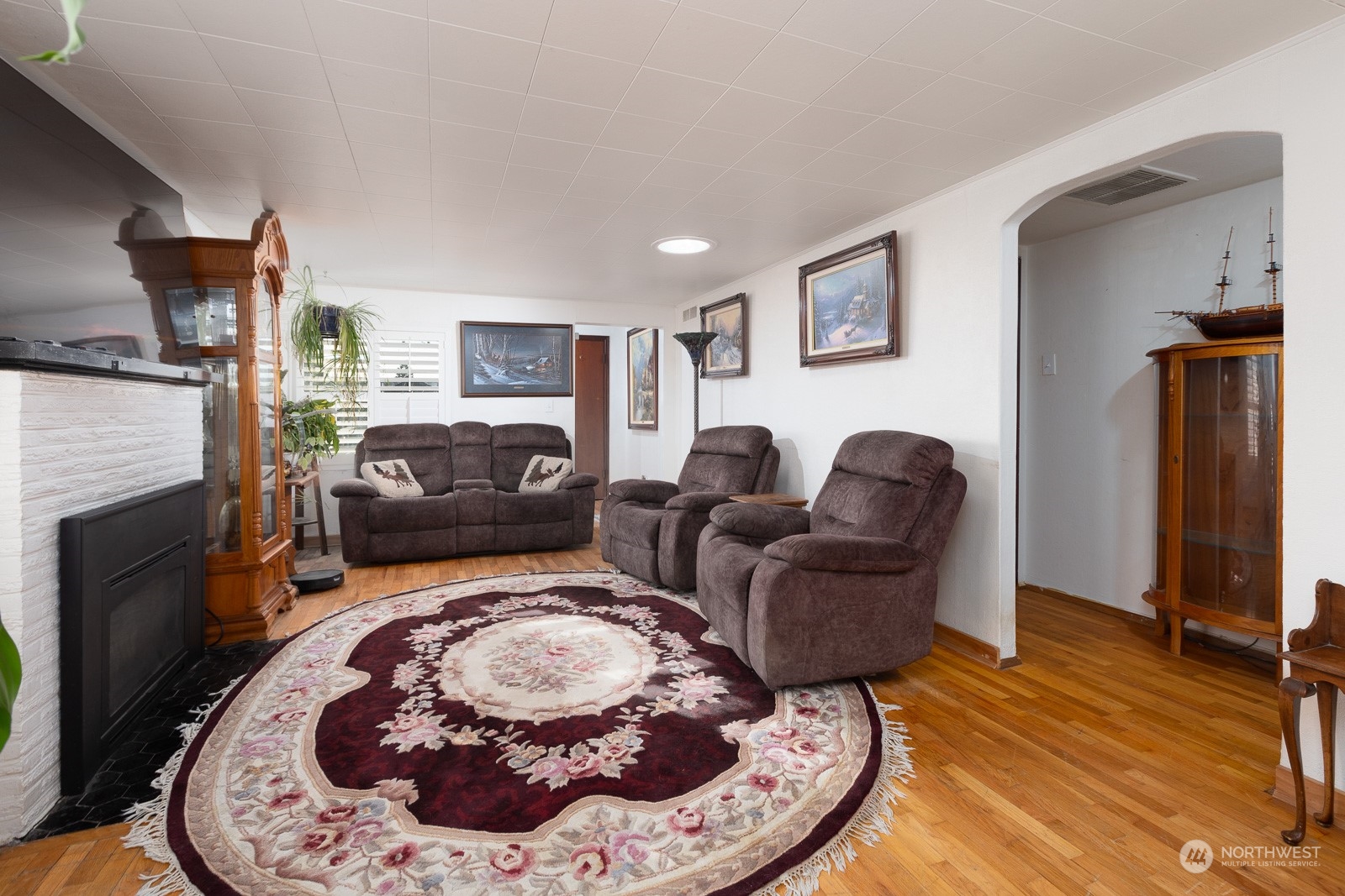 Looking towards the entry way, you see the hallway on the right that leads to two bedrooms and two bathrooms.  The oak hardwood floors have a lovely glow to them.