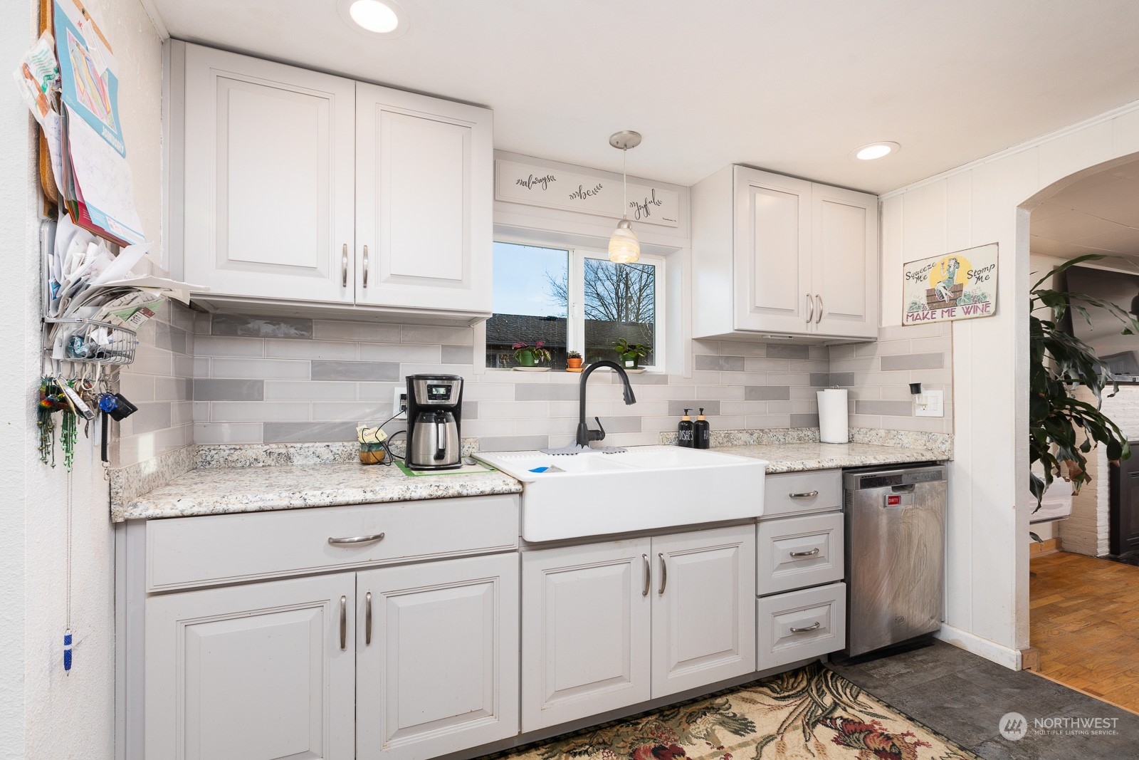 The kitchen has been updated as you can see.  New cabinets and hardware, a garden sink with new faucet, a lovely pendant over the sink, new glass tile backsplash, new countertops. New flooring and recessed lighting too!