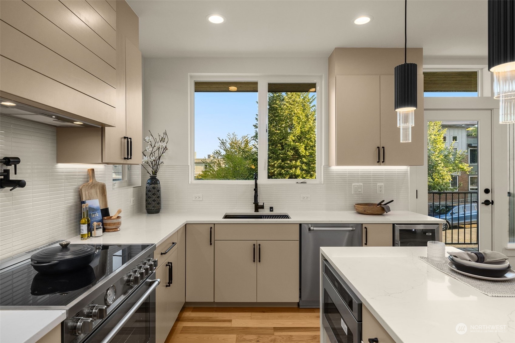 Discover the perfect blend of style and sophistication in this kitchen featuring light-colored cabinetry, premium stainless steel appliances, and exquisite quartz countertops.