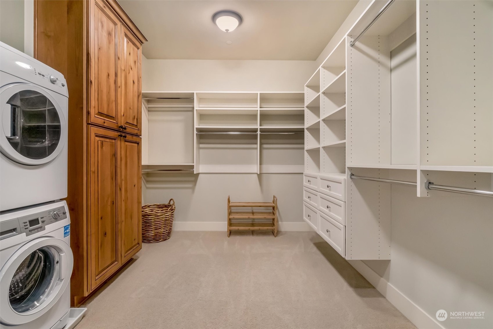 Primary walk in closet with stackable washer and  dryer for the utmost convenience.