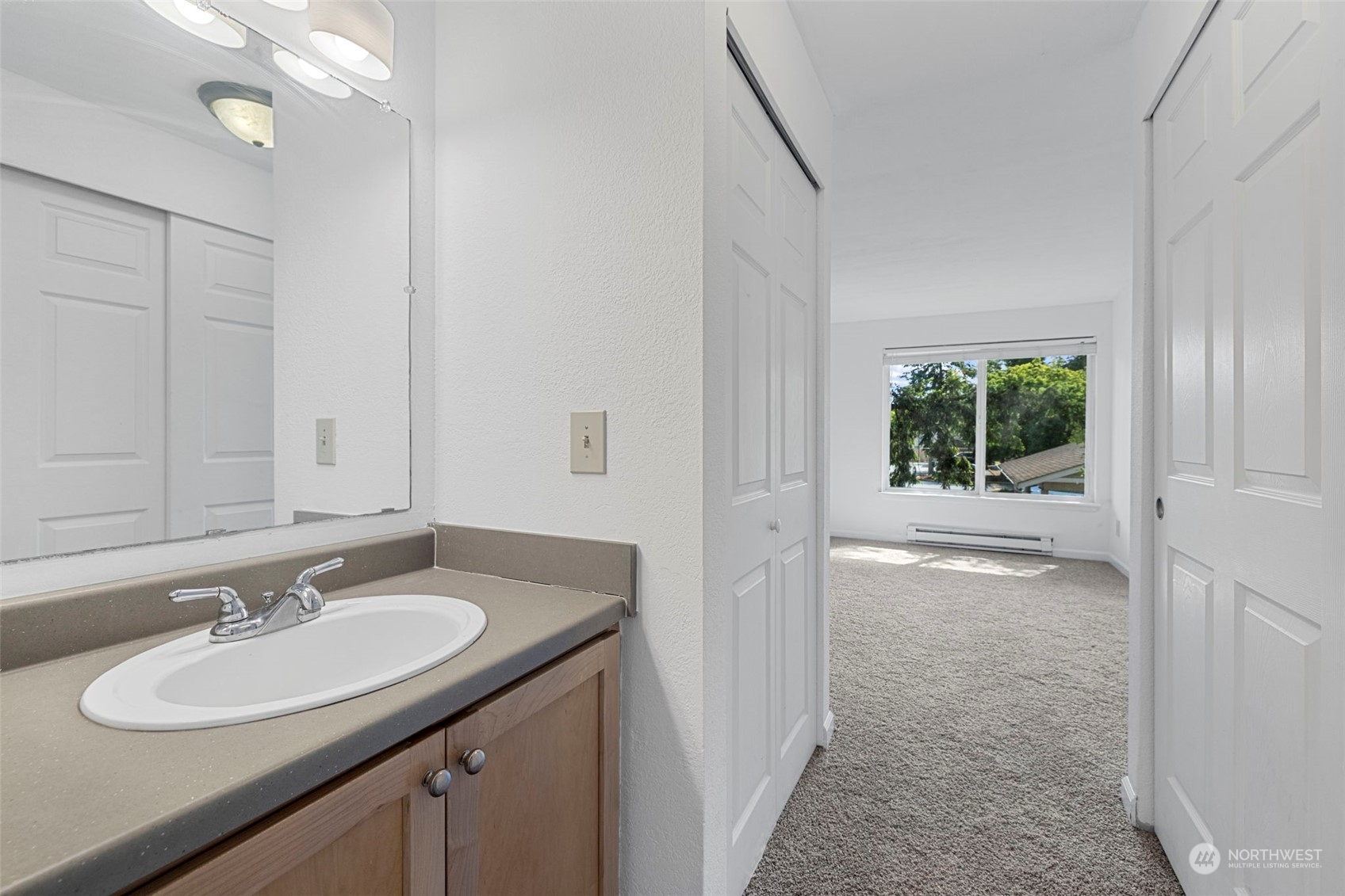 The primary bedroom offers a private vanity area with a sink, providing your own space to get ready outside the main bathroom—perfect for added convenience and privacy.