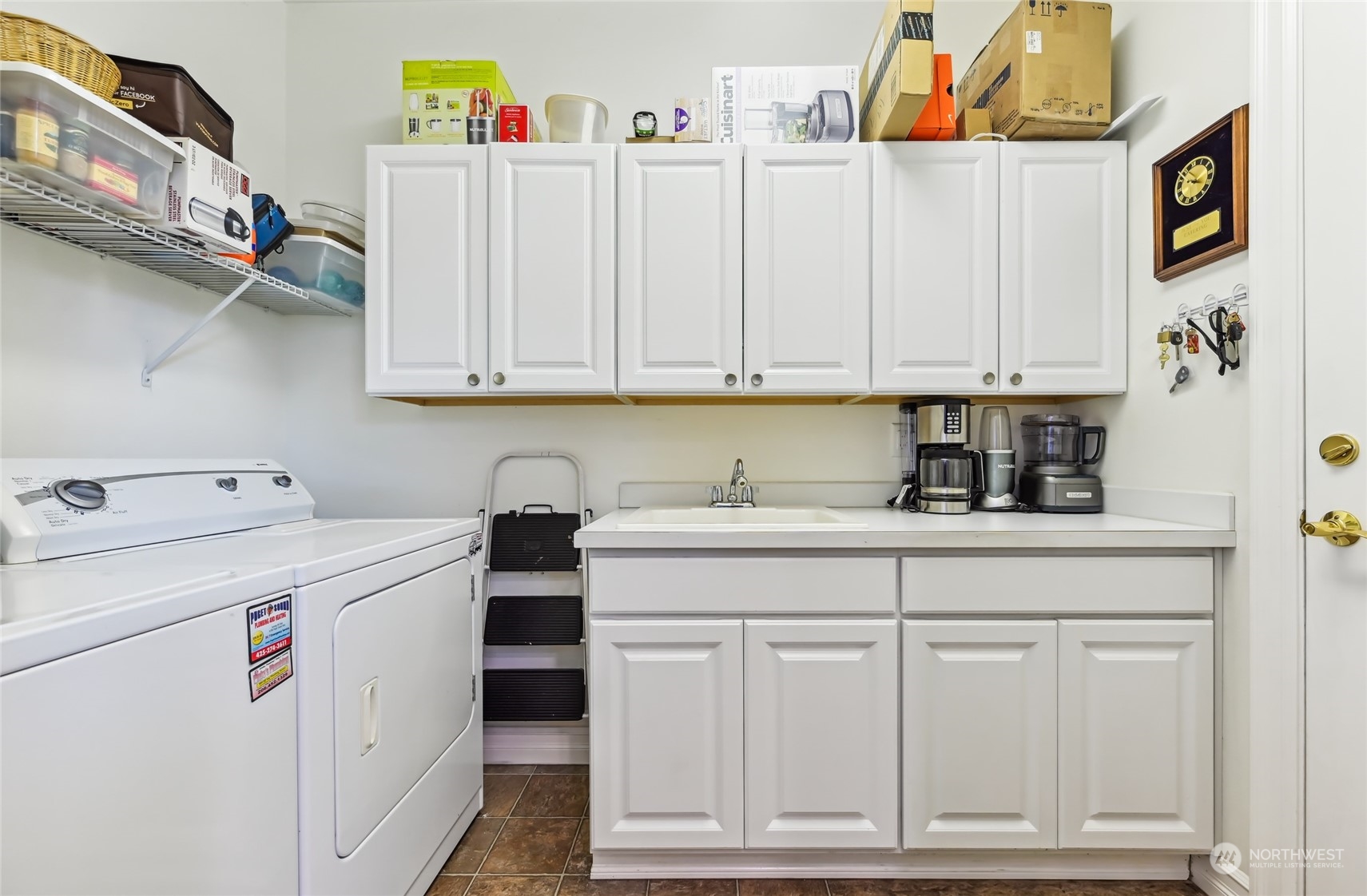 Fantastic laundry room with built-in cabinets, a utility sink and folding area. The washer and dryer are included with the sale.