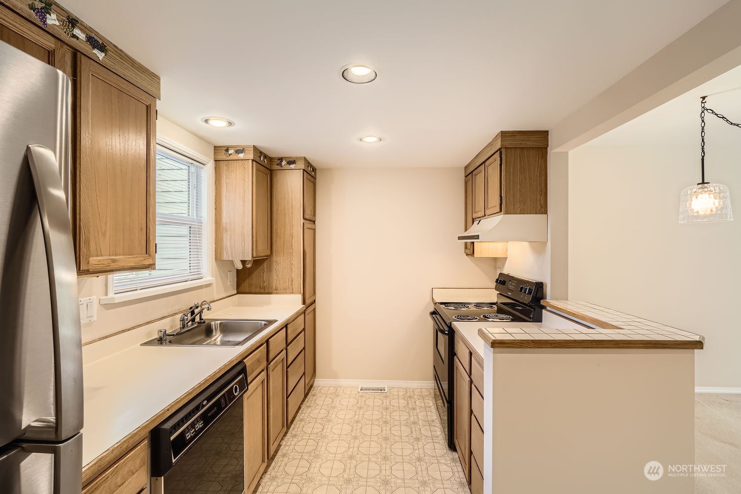 Another view of this clean and efficient kitchen with plenty of cabinet and counterspace.