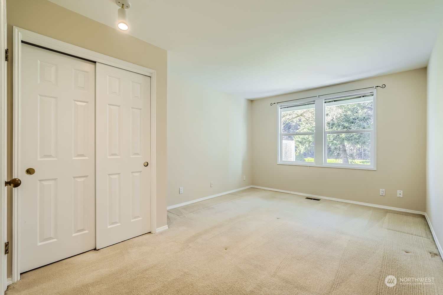 The spacious bedroom has large view windows to view the lovely greenspace and back patio.