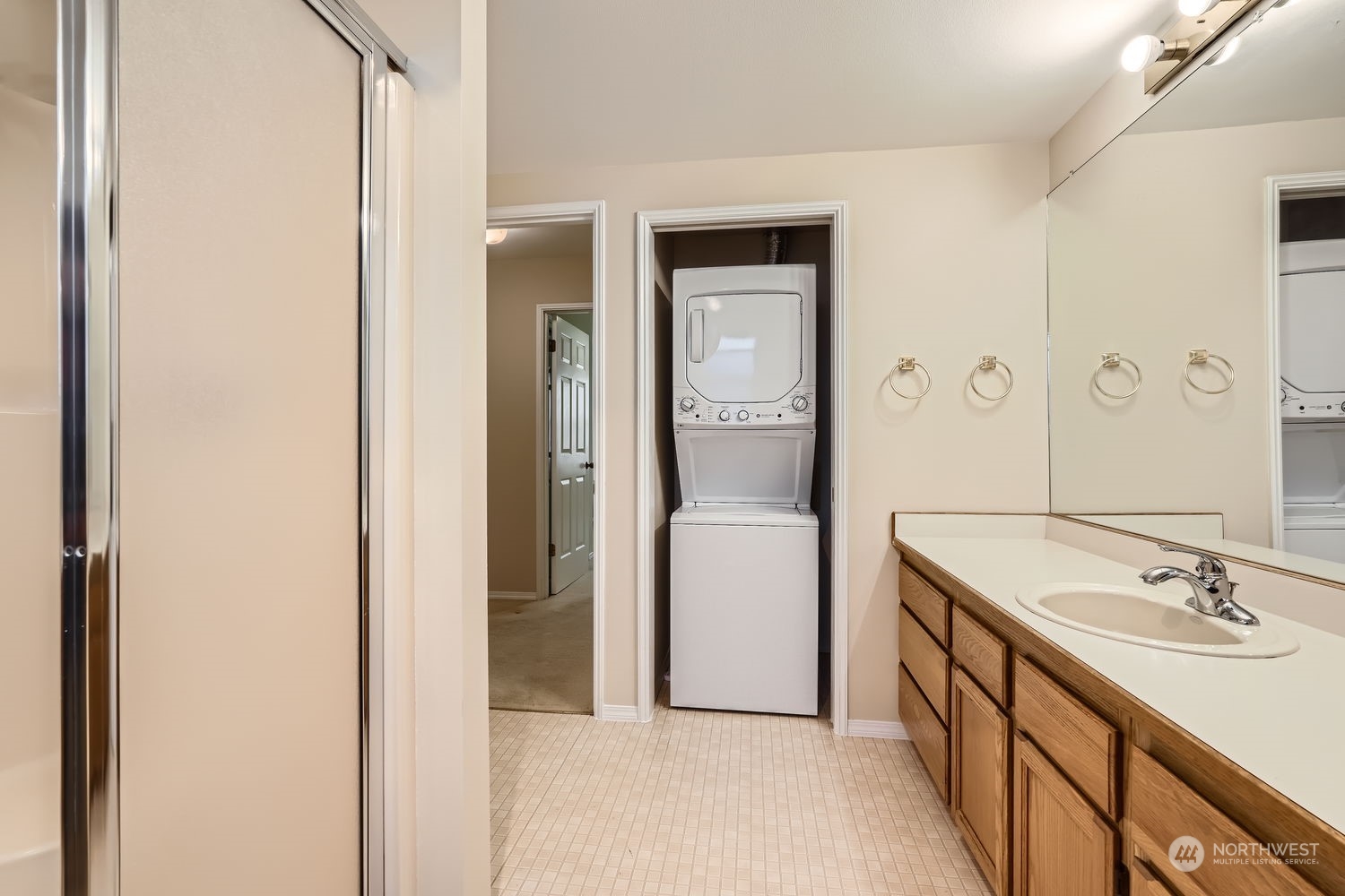 The large bathroom has a walk-in shower, newer stacked washer and dryer and great lighting. The newer water heater is to the right of the washer and dryer.