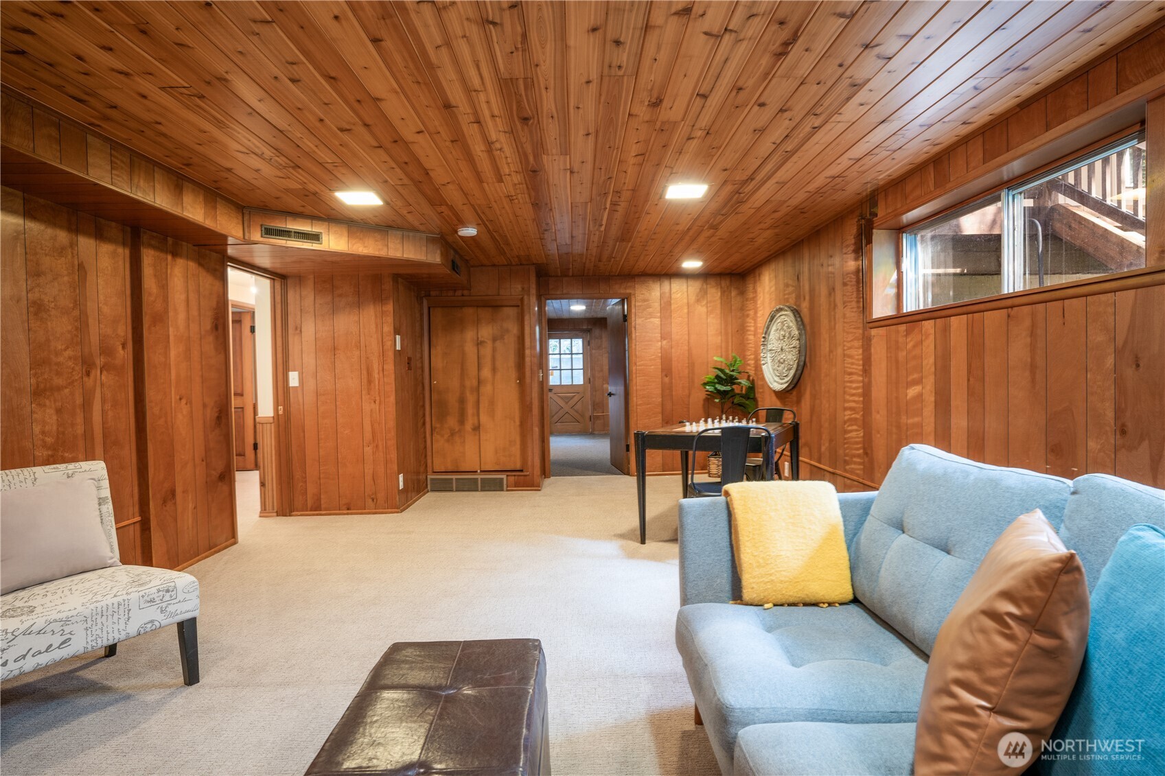 Another view of the lower level family room with the utility room beyond with separate entry. Doorway on the left leads to hall with 2 bedrooms & bathroom. This space offer opportunity for multi - generational living!