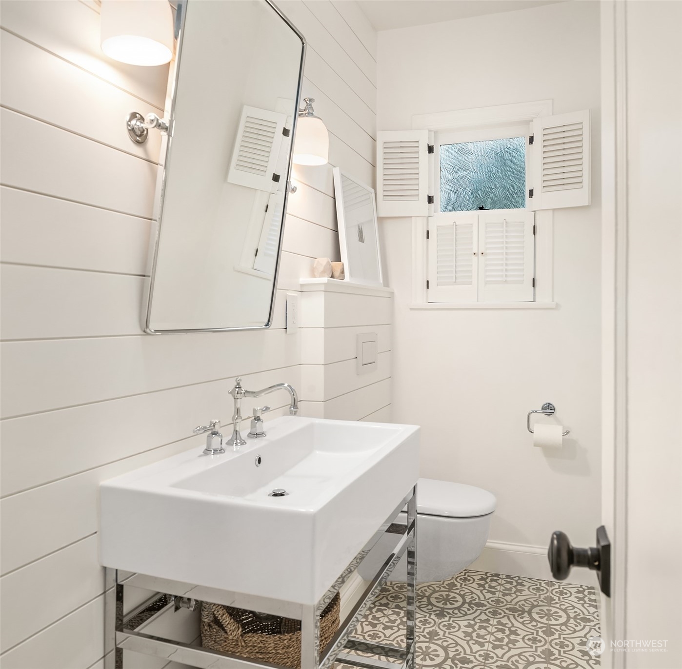 The most adorable main floor powder room with pedestal sink, chrome fixtures and white shiplap