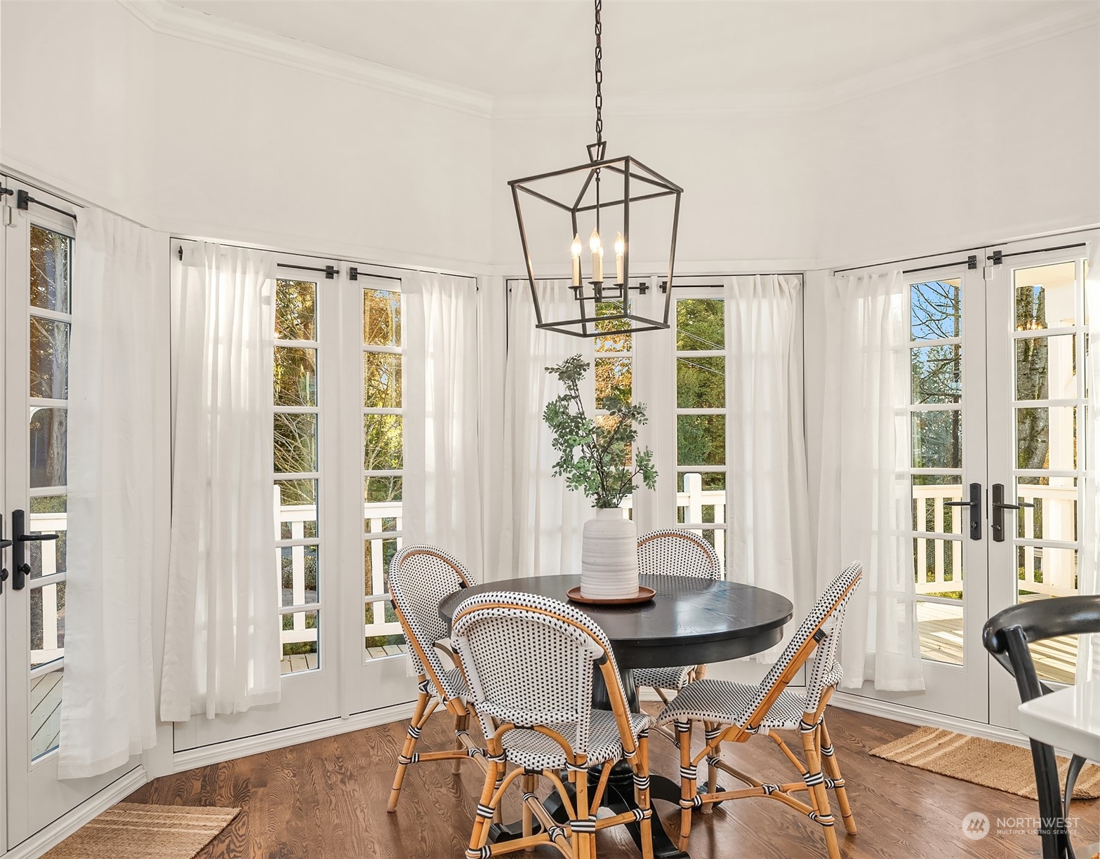 The informal dining room is a charming retreat, surrounded by French doors and windows that open onto the deck, creating a light and airy ambiance.