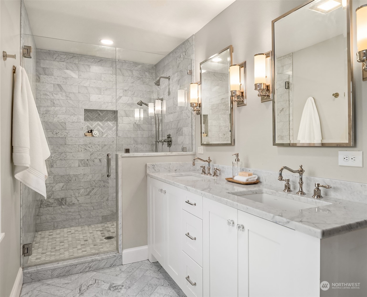 Ensuite-primary bathroom with dual vanities.   Classic and timeless marble with white shaker style cabinetry and chrome fixtures.