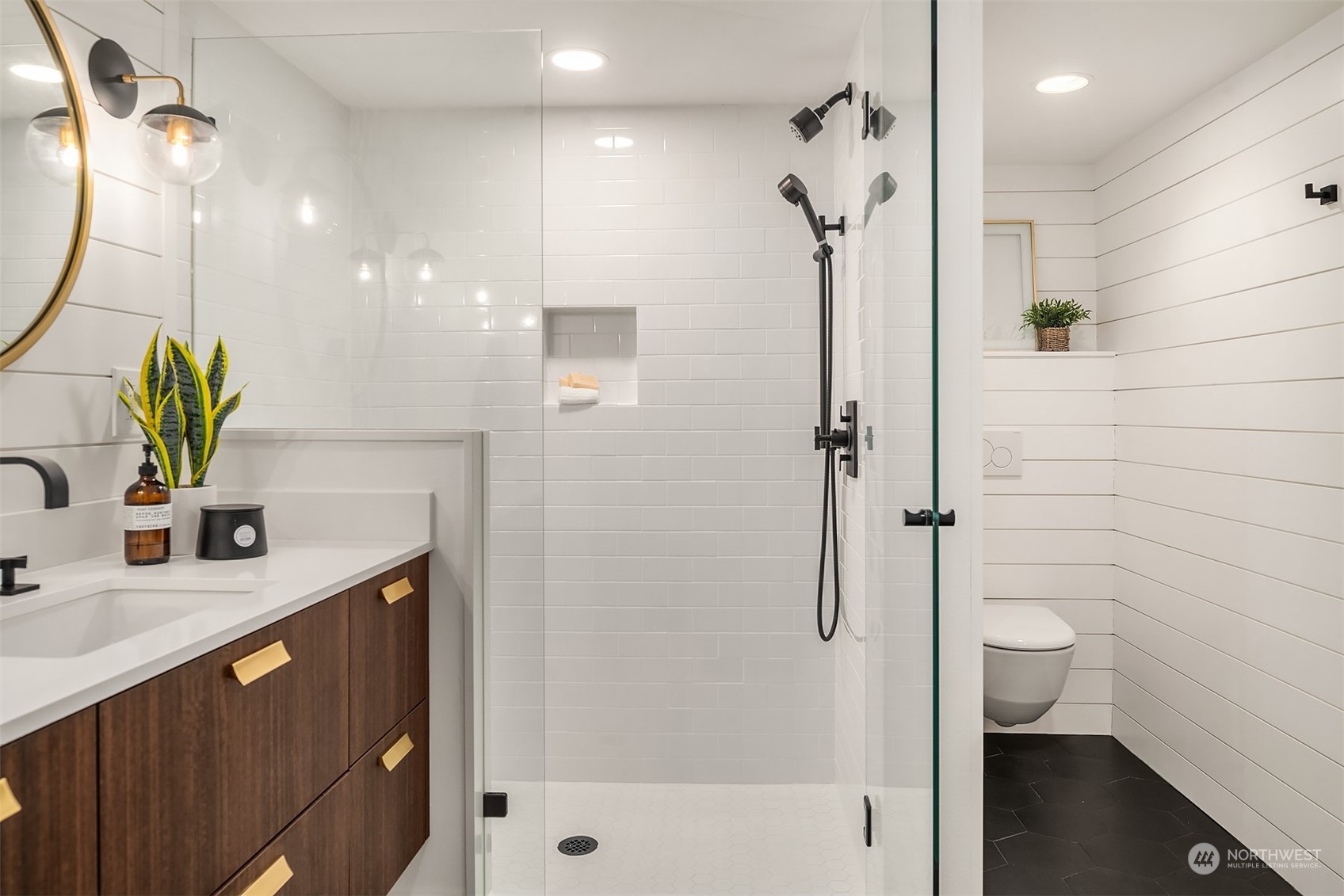 Lower level 3/4 bathroom with oversized walk-in shower,  shiplap accents, wall-mounted toilet and floating vanity with quartz countertops - accessible from the lower level bedroom or the hallway