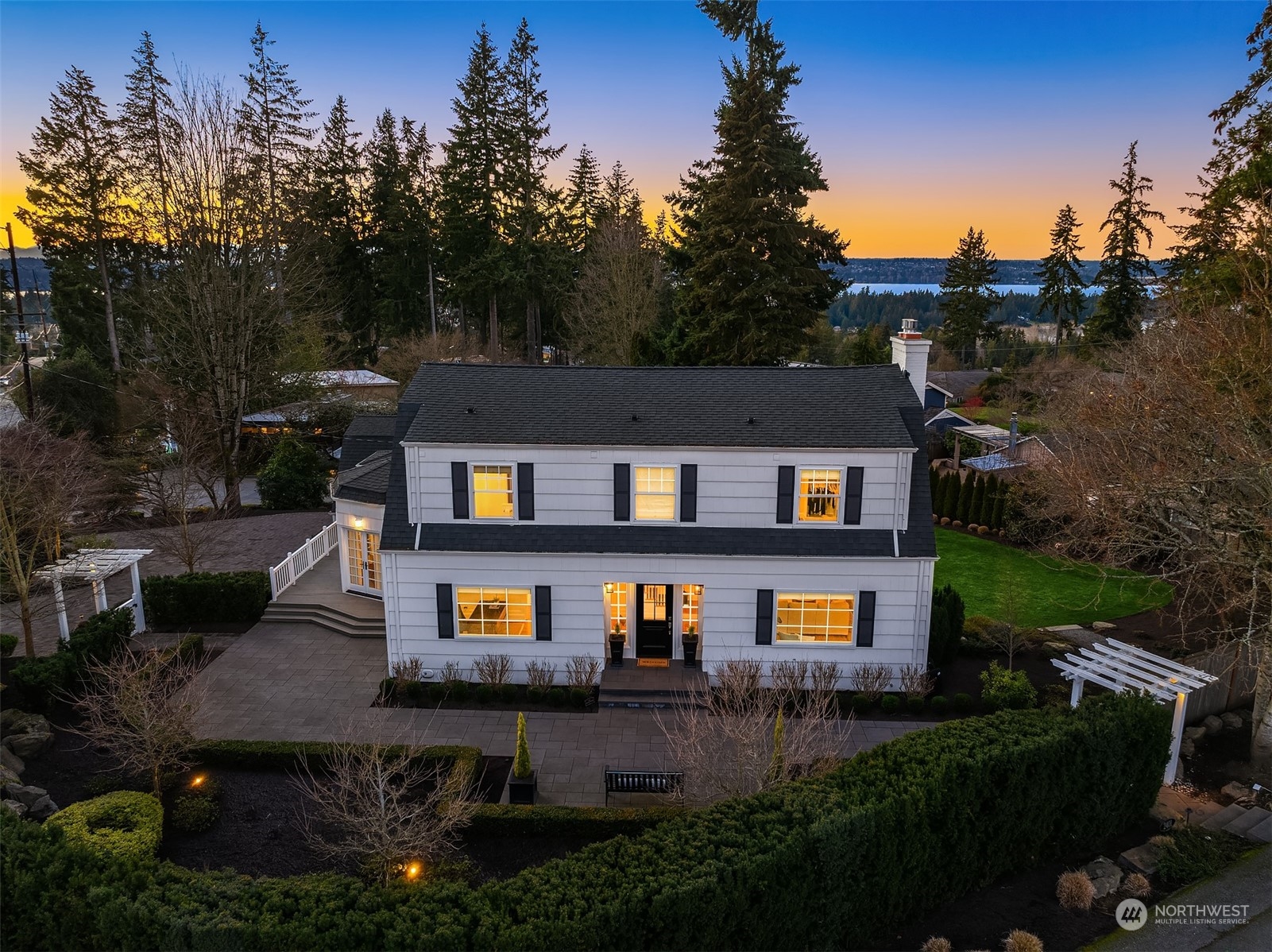 Surrounded by lush, mature landscaping, the property offers privacy, serenity, and partial multi-story views of Lake Washington and the Olympics