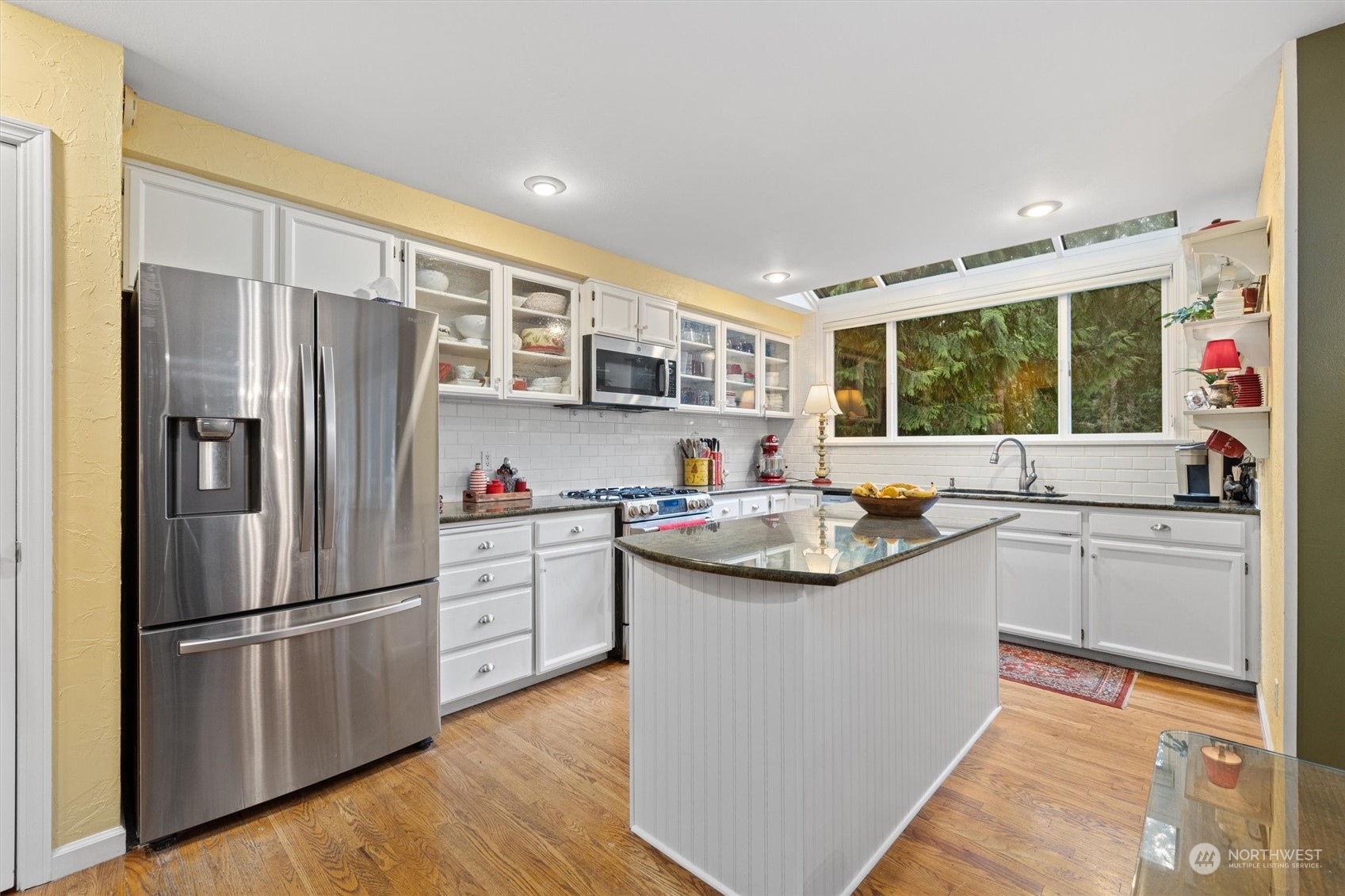 Bright Open Kitchen with Sky Wall Windows and View of Park