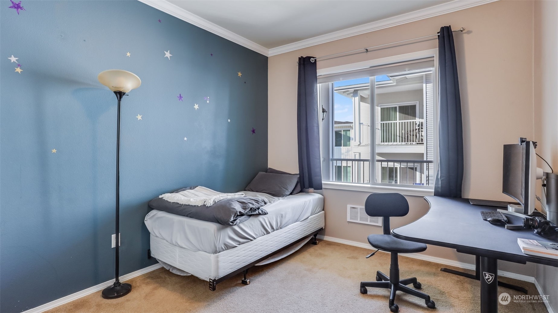 Ample sized guest bedroom with large window.