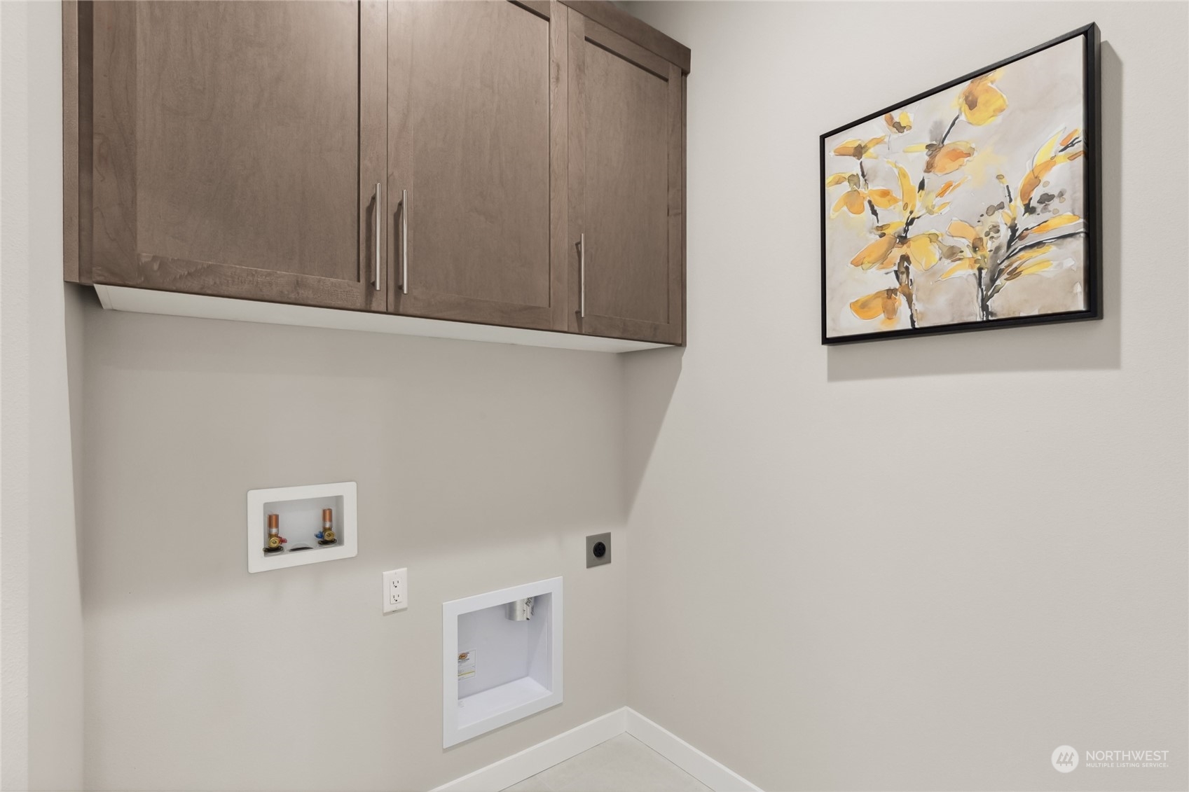 Convenient upstairs laundry room with storage cabinets.