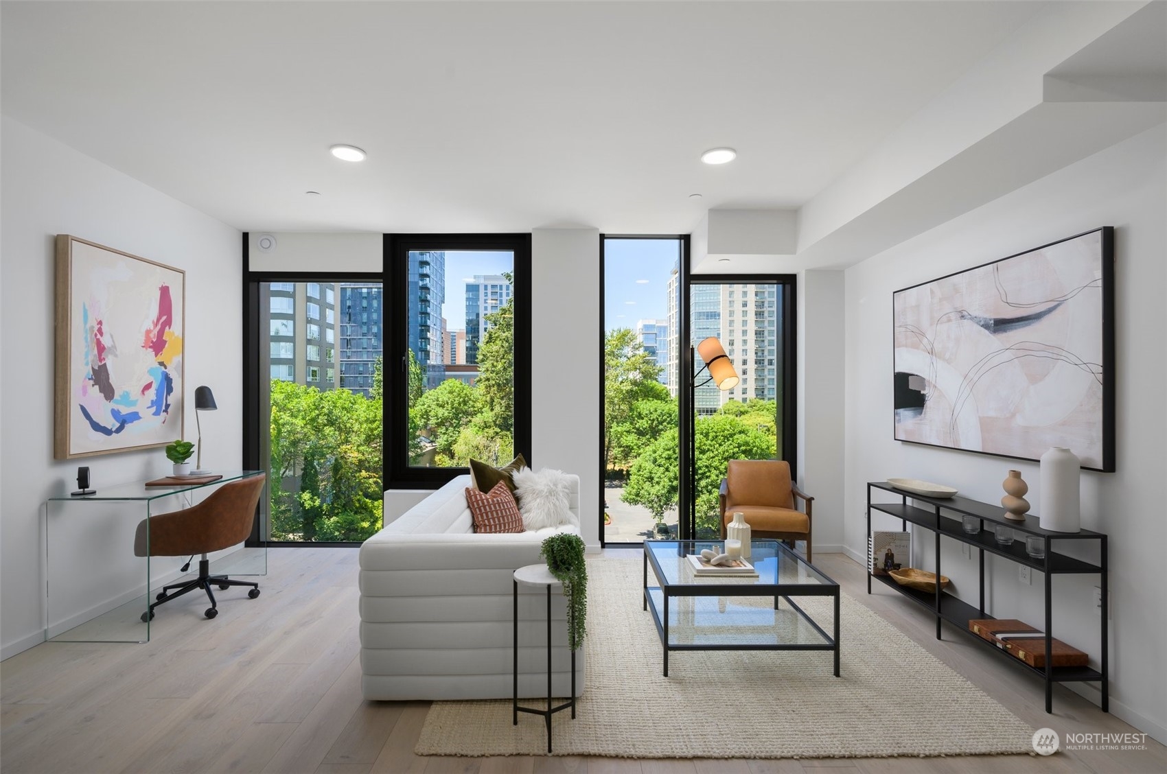 Living area features operable floor-to-ceiling windows, engineered hardwoods, ceiling Mitsubishi mini-split, and ample space for a home office.