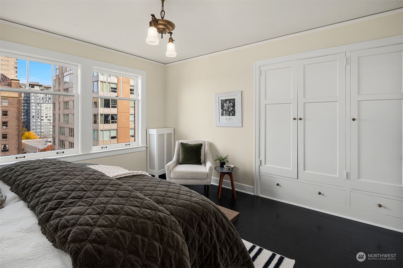 Another angle of this generous bedroom, showing period lighting, urban view and generous built in closet space.