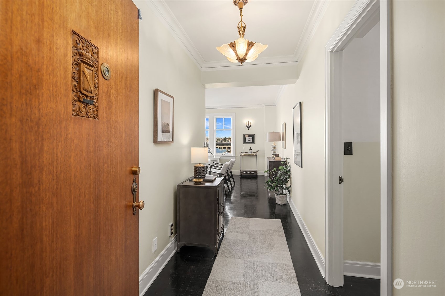 A truly welcoming entry with vintage art deco chandelier beckons all who enter. The living room, dining and kitchen are to the left, and two generous bedrooms and full bath are to the right.