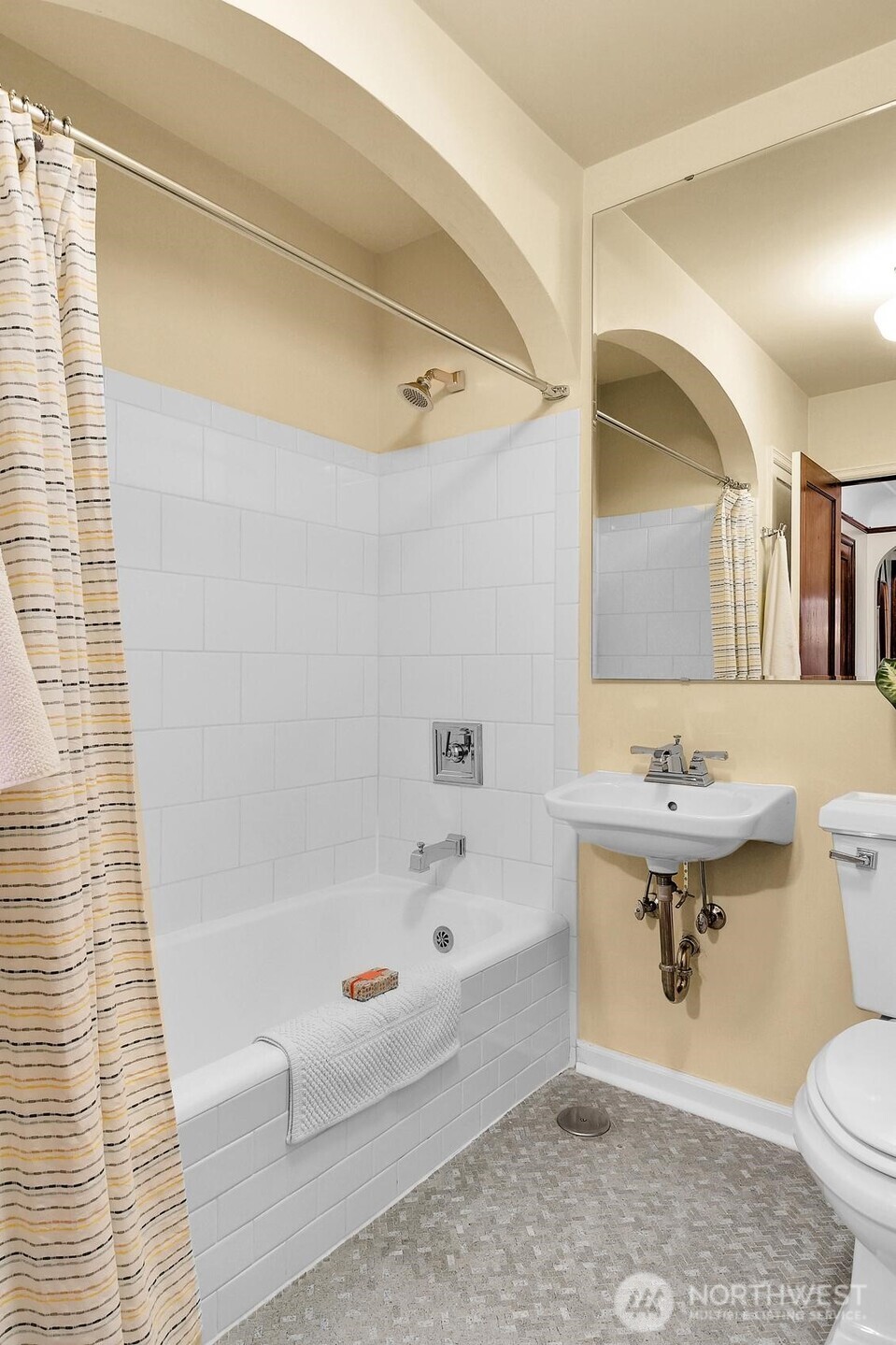 Full bath with tile surround and original tile floor.